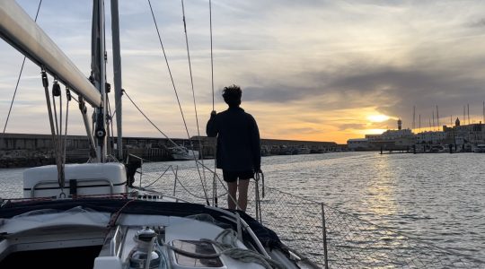 Velero entrando en el puerto de Rota al atardecer, imagen utilizada para ilustrar un artículo sobre las oposiciones de Lengua 2026.